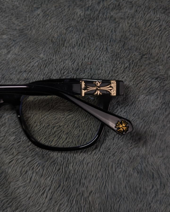 Black and gold glasses on a textured gray surface