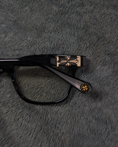 Black and gold glasses on a textured gray surface