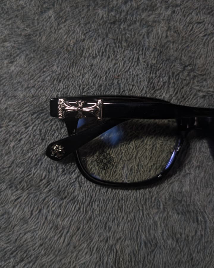 Black glasses with a silver frame on a gray textured surface