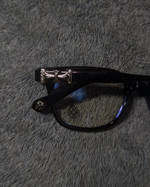 Black glasses with a silver frame on a gray textured surface